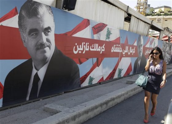A Lebanese woman passes a portrait of slain Lebanese Prime Minister Rafik Hariri near his grave Thursday in downtown Beirut, Lebanon.